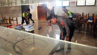 Warga yang dibantu anggota polisi mulai bergotong royong untuk membersihkan rumah hingga fasilitas umum dari air banjir.