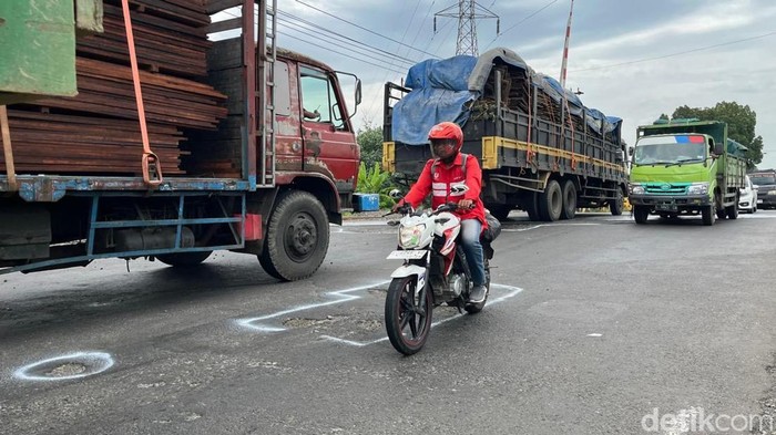 Cegah Kecelakaan Polisi Tandai Jalan Berlubang di Mojokerto dengan Cat Putih