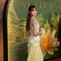 Bagian atas gaunnya memiliki detail jahitan jala dan korset putih, berhias payet perak dan mutiara. Sementara bagian penghubung korset dengan rok berwarna kuning yang menjuntai dibuat menyerupai bentuk bungai teratai. Selaras dengan judul serial Lisa BLACKPINK, The White Lotus 3. Foto: Getty Images