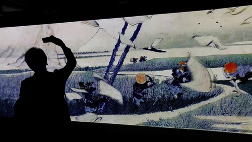 A visitor attends an exhibition that uses cutting-edge technology to bring to life the work of iconic samurai-era ukiyo-e artist Katsushika Hokusai at 'HOKUSAI: ANOTHER STORY in TOKYO', technical wizardry from Sony PCL Inc. and Ars Techne Corp, and the woodblock prints provided by the Yamanashi Prefectural Museum that owns the original work, during a preview event in Tokyo, Japan January 30, 2025.  REUTERS/Issei Kato