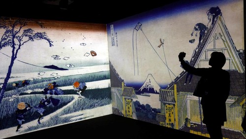 A visitor attends an exhibition that uses cutting-edge technology to bring to life the work of iconic samurai-era ukiyo-e artist Katsushika Hokusai at 'HOKUSAI: ANOTHER STORY in TOKYO', technical wizardry from Sony PCL Inc. and Ars Techne Corp, and the woodblock prints provided by the Yamanashi Prefectural Museum that owns the original work, during a preview event in Tokyo, Japan January 30, 2025.  REUTERS/Issei Kato