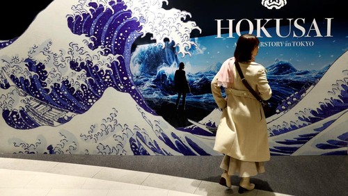 A visitor attends an exhibition that uses cutting-edge technology to bring to life the work of iconic samurai-era ukiyo-e artist Katsushika Hokusai at 'HOKUSAI: ANOTHER STORY in TOKYO', technical wizardry from Sony PCL Inc. and Ars Techne Corp, and the woodblock prints provided by the Yamanashi Prefectural Museum that owns the original work, during a preview event in Tokyo, Japan January 30, 2025.  REUTERS/Issei Kato