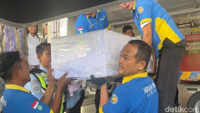 Petugas saat mengangkat peti jenazah WNI korban penembakan ke ambulans. (Finta Rahyuni/detikSumut)