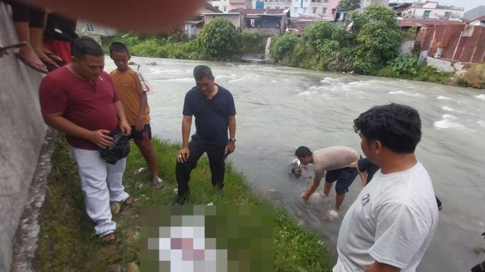 Pihak kepolisian saat mengevakuasi bayi dari sungai. (Foto: Dok. Polsek Siantar Timur).