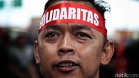 Para sopir truk kontainer kompak memakai ikat kepala berwarna merah dalam aksi di depan pelabuhan tersebut.  