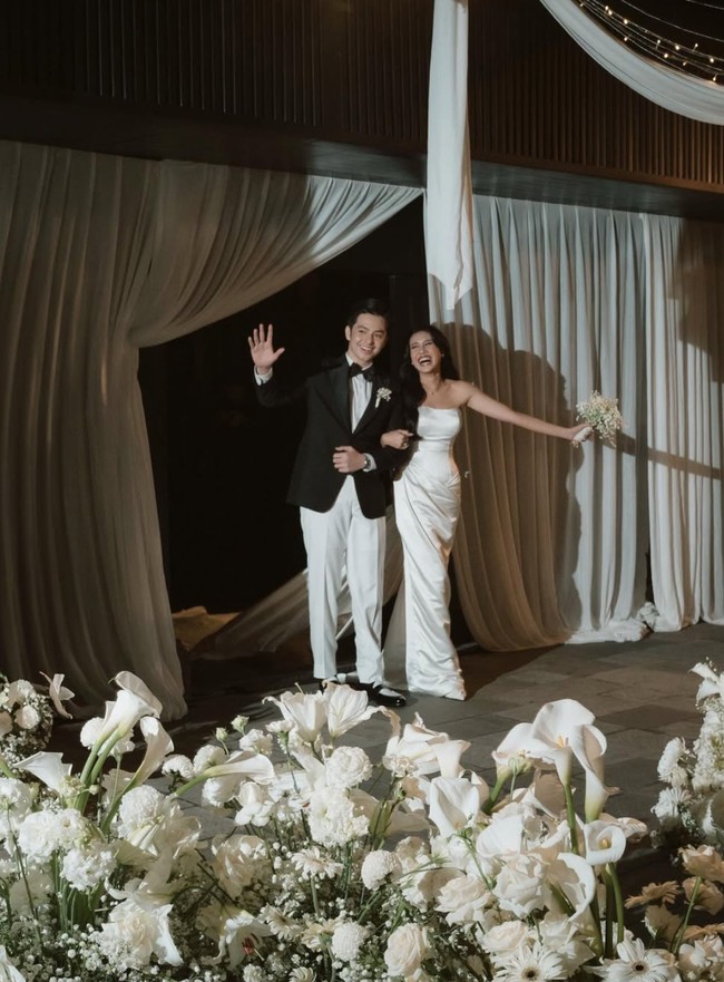 Berbeda dengan akad nikah yang mengusung adat Minang, di resepsi pernikahan Angga dan Shenina memilih mengenakan baju pengantin internasional. Angga tampil gagah dengan jas hitam dan celana putih dipadukan dasi kupu-kupu. Sementara Shenina terlihat menawan dengan gaun tube putih polos berbahan satin. Foto: Instagram/@sheninacinnamon