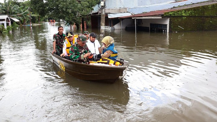 Seorang anggota Babinsa menaiki perahu untuk melihat kondisi banjir di Perumnas Antang, Makassar, Sulawesi Selatan, Rabu (12/2/2025). Ratusan rumah yang tersebar di empat kecamatan di daerah itu terendam banjir sejak Senin (10/2) akibat hujan dengan intensitas tinggi yang bersamaan dengan terjadinya gelombang pasang air laut.