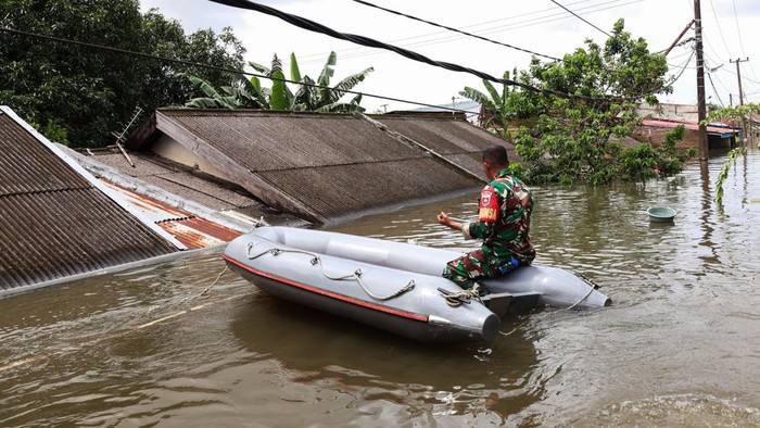Seorang anggota Babinsa menaiki perahu untuk melihat kondisi banjir di Perumnas Antang, Makassar, Sulawesi Selatan, Rabu (12/2/2025). Ratusan rumah yang tersebar di empat kecamatan di daerah itu terendam banjir sejak Senin (10/2) akibat hujan dengan intensitas tinggi yang bersamaan dengan terjadinya gelombang pasang air laut.