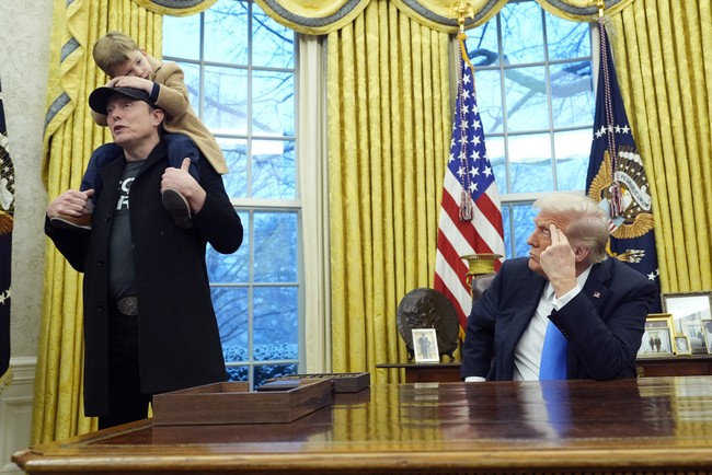 Elon Musk dan X berdiri di belakang Presiden Trump, saat dia menandatangani perintah eksekutif untuk memangkas jumlah pegawai federal di Oval Office. Foto: AP/Alex Brandon