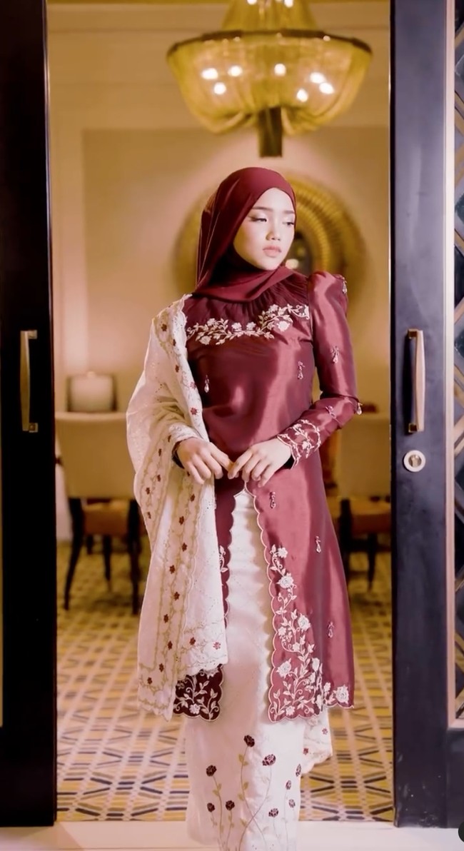 Tampil bak wanita Malaysia, Fuji mengenakan baju kurung berwarna merah marun dipadukan dengan rok panjang putih. Pakaian yang dikenakan Fuji itu juga tampak memiliki aksen floral yang mempermanis tampilan. Foto: Instagram/@hijabista.hub