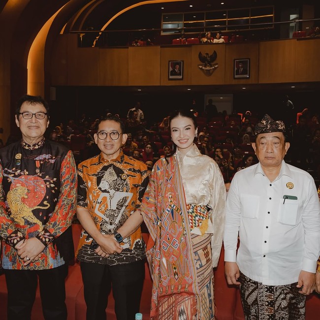 Adapun ayah Raline memakai kemeja kontemporer berkerah mandarin yang mendapat sentuhan batik. Busana yang dihiasi gambar harimau itu hadir dalam perpaduan warna yang serasi dengan penampilan Raline. (Foto: Instagram/@ralineshah)