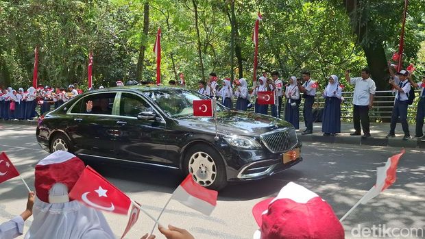 Kedatangan Presiden Turki Recep Tayyip Erdogan ke Istana Bogor disambut pelajar dan warga. Erdogan merespons dengan melambaikan tangan melalui jendela mobilnya. (M Sholihin/detikcom)