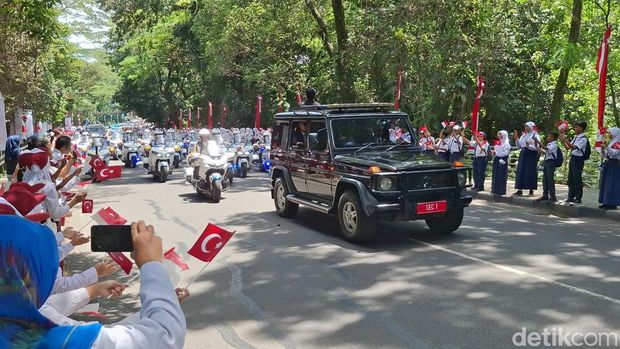 Kedatangan Presiden Turki Recep Tayyip Erdogan ke Istana Bogor disambut pelajar dan warga. Erdogan merespons dengan melambaikan tangan melalui jendela mobilnya. (M Sholihin/detikcom)