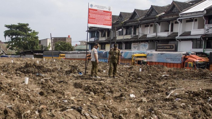 Petugas Satpol PP Kota Bandung berdiri di dekat papan informasi penyegelan di Tempat Pembuangan Sementara (TPS) Pasar Caringin, Bandung, Jawa Barat, Selasa (11/2/2025). Tim Penegakan Hukum Kementerian Lingkungan Hidup (KLH) menyegel dan menutup TPS tersebut akibat melakukan pelanggaran lingkungan terkait pengelolaan dalam menimbun sampah dan membakar sampah memakai insenerator tanpa izin.