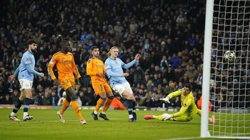 Manchester Citys Erling Haaland shoots to score past Real Madrids goalkeeper Thibaut Courtois, right, during the Champions League playoff first leg soccer match between Manchester City and Real Madrid at the Etihad Stadium in Manchester, England, Tuesday, Feb. 11, 2025. (AP Photo/Dave Thompson)