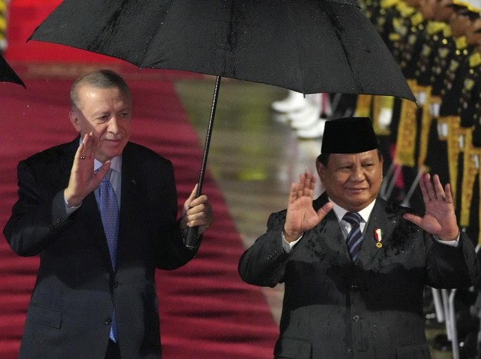 Turkeys President Recep Tayyip Erdogan, center, and his wife Emine, left, are greeted by Indonesian President Prabowo Subianto, right, upon their arrival at Halim Perdanakusuma International Airport in Jakarta, Indonesia, Tuesday, Feb. 11, 2025. (AP Photo/Achmad Ibrahim)