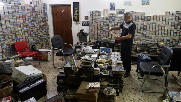 Sabah Al-Sudani who runs two shops selling audio cassettes and other vintage items of yesteryear, speaks with a customer at his shop, in Baghdad, Iraq, January 21, 2025. The once ubiquitous audio cassette is now seen by many as a relic of simpler times, but for Sudani the cassettes offer a nostalgia to a period he feels Arab music saw its peak. REUTERS/Ahmed Saad