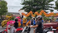Sejumlah warga turut menanti aksi barongsai di sepanjang jalan.