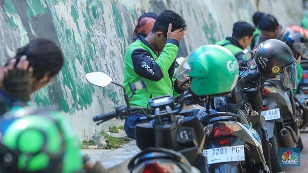 Pengemudi ojek online (ojol) menunggu orderan di kawasan Palmerah, Jakarta, Rabu (12/2/2025). Masyarakat Transportasi Indonesia (MTI) mengusulkan agar ojek online di Jakarta bisa mendapatkan bahan bakar minyak (BBM) subsidi dengan cara menggunakan plat kuning dalam upaya mendorong masyarakat untuk beralih ke angkutan umum. (CNBC Indonesia/Faisal Rahman)