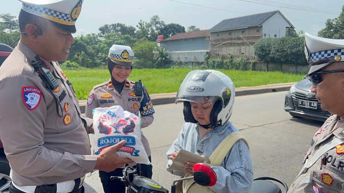 Polisi memberhentikan pemotor tertib untuk diberi hadiah