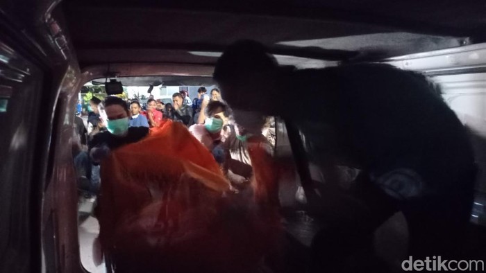 Polisi mengevakuasi jenazah korban yang ditemukan tewas di dalam rumah.