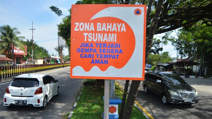 Pengendara sepeda motor melintas di dekat rambu zona bahaya tsunami yang baru dipasang di Jl Adinegoro Padang, Sumatera Barat, Selasa (11/2/2025). BPBD Padang menambah rambu-rabu zona bahaya (merah) gelombang tsunami di pesisir pantai kota itu yang dihuni sekitar 60 persen warga Padang. ANTARA FOTO/Iggoy el Fitra/rwa.