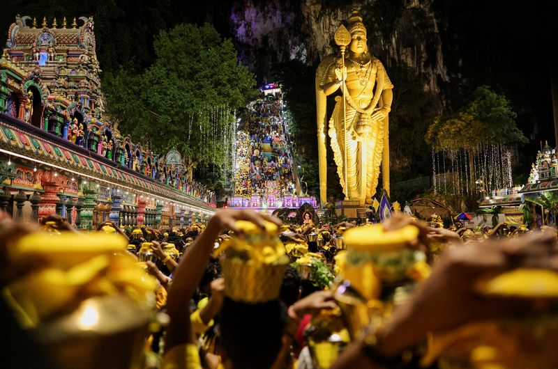 Hindu devotees carry pots of milk as they make their way to the Sri Subramaniar Swamy Temple during the Thaipusam celebrations at Batu Caves, Malaysia February 11, 2025. REUTERS/Hasnoor Hussain      TPX IMAGES OF THE DAY