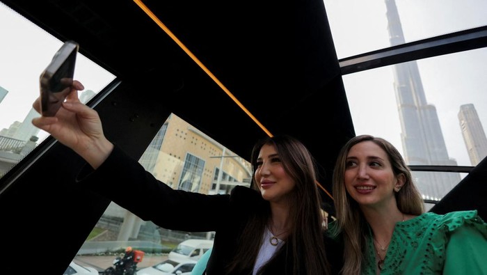 People enjoy drinks and snacks on the deck of Bustronomy, a double-decker restaurant bus, in Dubai, United Arab Emirates, February 1, 2025. REUTERS/Amr Alfiky