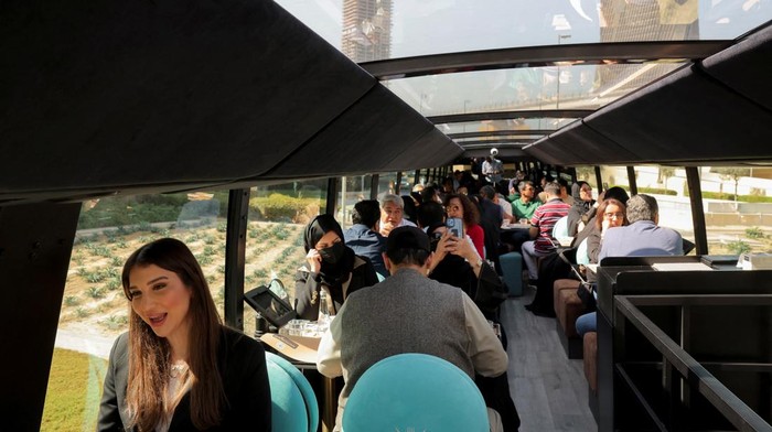 People enjoy drinks and snacks on the deck of Bustronomy, a double-decker restaurant bus, in Dubai, United Arab Emirates, February 1, 2025. REUTERS/Amr Alfiky