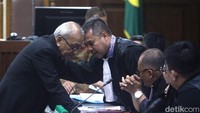 Donald Sihombing berkonsultasi dengan kuasa hukumnya. 