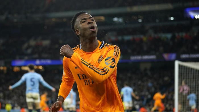 Real Madrids Vinicius Junior celebrates after his teammate Real Madrids Brahim Diaz scored their side second goal during the Champions League playoff first leg soccer match between Manchester City and Real Madrid at the Etihad Stadium in Manchester, England, Tuesday, Feb. 11, 2025. (AP Photo/Dave Thompson)
