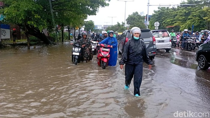 Warga mendorong motor yang mogok di Jalan Perintis Kemerdekaan Makassar.