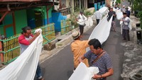Warga suku Osing melipat kain kafan (lawon) usai dibersihkan di Balai Tajuk Cungking, Banyuwangi, Jawa Timur, Kamis (13/2/2025).