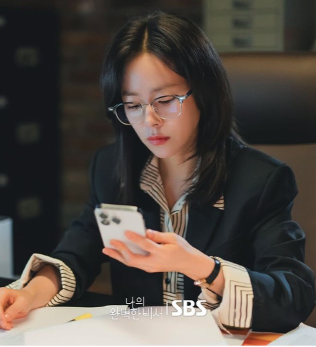 Gaya Han Ji Min di Love Scout selanjutnya yang bisa menginspirasi ketika memakai perpaduan striped shirt dan blazer hitam. Agar tidak terlalu kaku, gulung saja bagian lengannya untuk memberikan kesan lebih kalem. Foto: dok. SBS 