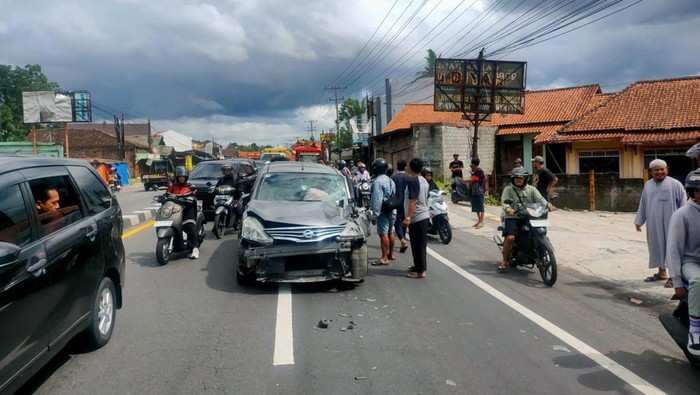 Sejumlah warga bersama petugas saat meminggirkan mobil Nissan Grand Livina yang mengalami kecelakaan di Jalan Jogja-Magelang di Pabelan, Kecamatan Mungkid, Kabupaten Magelang, Kamis (13/2/2025).