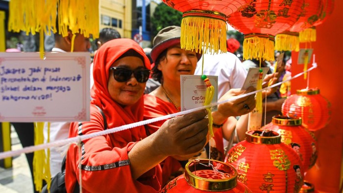 Warga menempelkan kertas pesan pada lentera harapan saat perayaan Cap Go Meh di kawasan Pecinan Glodok, Jakarta, Rabu (12/2/2025). Puncak perayaan Tahun Baru Imlek 2576 tersebut menampilkan perpaduan seni budaya Tionghoa dan Betawi dengan tema Jati Diri Indonesia, Megapolitan Dunia. ANTARA FOTO/Sulthony Hasanuddin/nym.