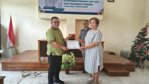 Kepala Dinkes Manggarai Barat Adrianus Ojo (kiri) memberikan Sertifikat Pelatihan Keamanan Pangan Siap Saji kepada salah satu Penjamah Pangan, Kamis (13/2/2024).