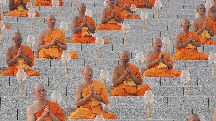 Thai Buddhists hold candles as they gather at Wat Dhammakaya temple to participate in Makha Bucha Day ceremonies in Pathum Thani, Thailand, Tuesday, Feb. 12, 2025. (AP Photo/Sakchai Lalit)