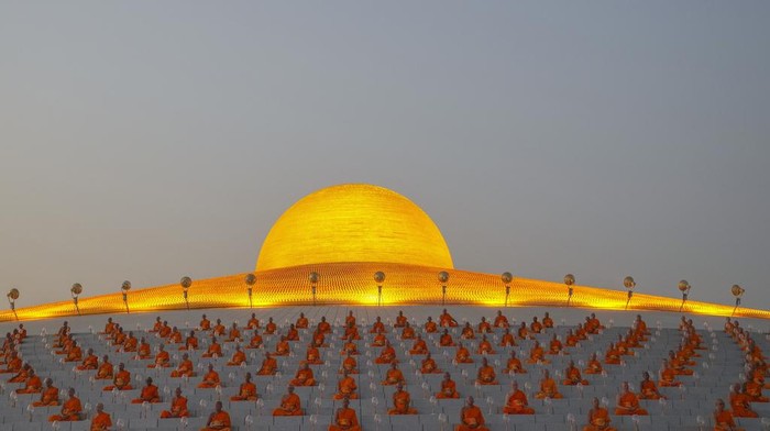 Thai Buddhists hold candles as they gather at Wat Dhammakaya temple to participate in Makha Bucha Day ceremonies in Pathum Thani, Thailand, Tuesday, Feb. 12, 2025. (AP Photo/Sakchai Lalit)