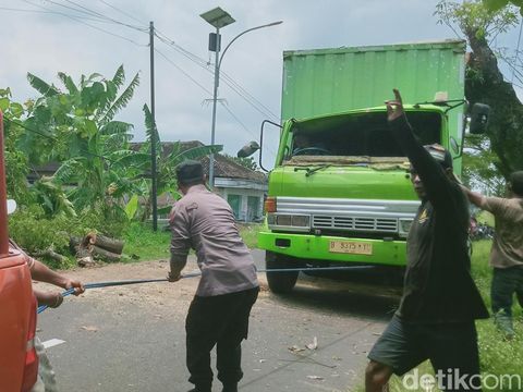 Evakuasi truk boks tertimpa pohon trembesi di jalan Delanggu-Wonosari, Desa Ngreden, Kecamatan Wonosari, Klaten, Jumat (14/2/2025).