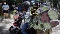 Penjual maupun kurir tampak sibuk dengan bunga-bunga yang dipesan pelanggan.
