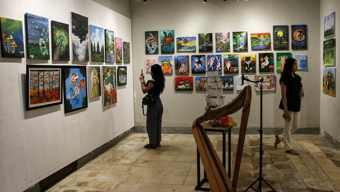 Pameran seni rupa Nostalgia Kalimantan Pengunjung mengamati lukisan yang dipajang pada pameran Nostalgia Kalimantan di Galeri Lawu, Palangka Raya, Kalimantan Tengah, Jumat (14/2/2025). Pameran yang diikuti 23 perupa Kota Palangka Raya tersebut menggambarkan tentang nostalgia Kalimantan yang menampilkan keindahan alam dan kekayaan budaya Pulau Borneo. ANTARA FOTO/Auliya Rahman/tom.