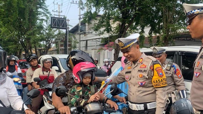 Kasatlantas Polres Probolinggo Kota AKP Siswandi memberikan helm kepada pengendara yang melintas