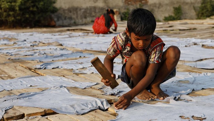 A boy hits nails on cowhides to keep them stretched while drying in sunlight, as he works in a tannery in Dhaka, Bangladesh, February 13, 2025. REUTERS/Mohammad Ponir Hossain