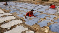 Seorang perempuan dan anak-anak memaku paku pada kulit sapi agar tetap meregang saat dijemur di bawah sinar matahari, saat mereka bekerja di tempat penyamakan kulit di Dhaka, Bangladesh, 13 Februari 2025.  