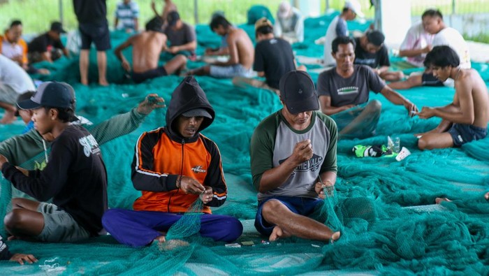 Sejumlah nelayan memperbaiki kapal di Pelabuhan Perikanan Muncar, Banyuwangi, Jawa Timur, Jumat (15/1/2025). Sebagian nelayan di daerah tersebut memilih untuk tidak melaut sejak 14 hari terahir karena dampak cuaca buruk dan mereka mengisi waktunya dengan memperbaiki jaring dan kapalnya. ANTARA FOTO/Budi Candra Setya/tom.
