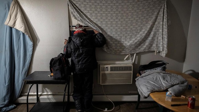 With his bag packed, a Venezuelan man peeks out the window of his apartment looking for any signs of federal agents after hearing reports that U.S. Immigration and Customs Enforcement will be coming to detain immigrants for deportation in Aurora, Colorado, U.S., January 30, 2025. U.S. President Donald Trump kicked off a wide-ranging immigration crackdown after taking office on January 20, allocating federal resources to track down, arrest and deport immigrants without legal status. REUTERS/Kevin Mohatt      SEARCH 