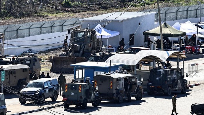 Israeli troops gather with their vehicles inside the Ofer military prison complex, located between Ramallah and Beitunia in the occupied West Bank, before releasing Palestinian prisoners as part of a hostage-prisoner exchange on February 15, 2025. Masked Hamas militants brought three Israeli hostages on stage in the southern Gaza city of Khan Yunis on February 15 ahead of their release in the sixth hostage-prisoner swap as agreed with Israel, an AFP journalist reported. (Photo by Zain JAAFAR / AFP)