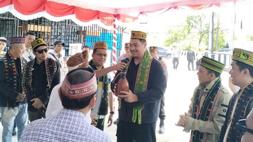 Anggota The Dudas Minus One bersama Menpora Dito Ariotedjo dan Wamenpora Taufik Hidayat memakai selendang dan songkok khas Manggarai di Labuan Bajo, Manggarai Barat, NTT, Minggu (16/2/2025) siang. (Ambrosius Ardin/detikBali)