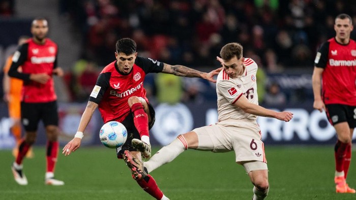 15 February 2025, North Rhine-Westphalia, Leverkusen: Soccer: Bundesliga, Bayer Leverkusen - Bayern Munich, Matchday 22, BayArena. Leverkusens Exequiel Palacios (l) and Munichs Joshua Kimmich fight for the ball. Photo: Marius Becker/dpa - IMPORTANT NOTE: In accordance with the regulations of the DFL German Football League and the DFB German Football Association, it is prohibited to utilize or have utilized photographs taken in the stadium and/or of the match in the form of sequential images and/or video-like photo series. (Photo by Marius Becker/picture alliance via Getty Images)